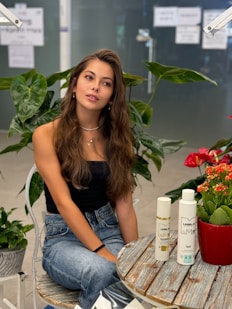 A woman sitting at a table surrounded by flowers