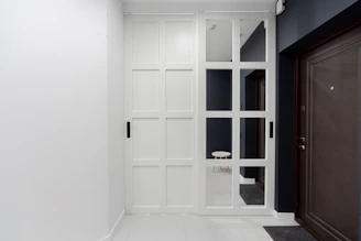 A white room with a black door and a brown door