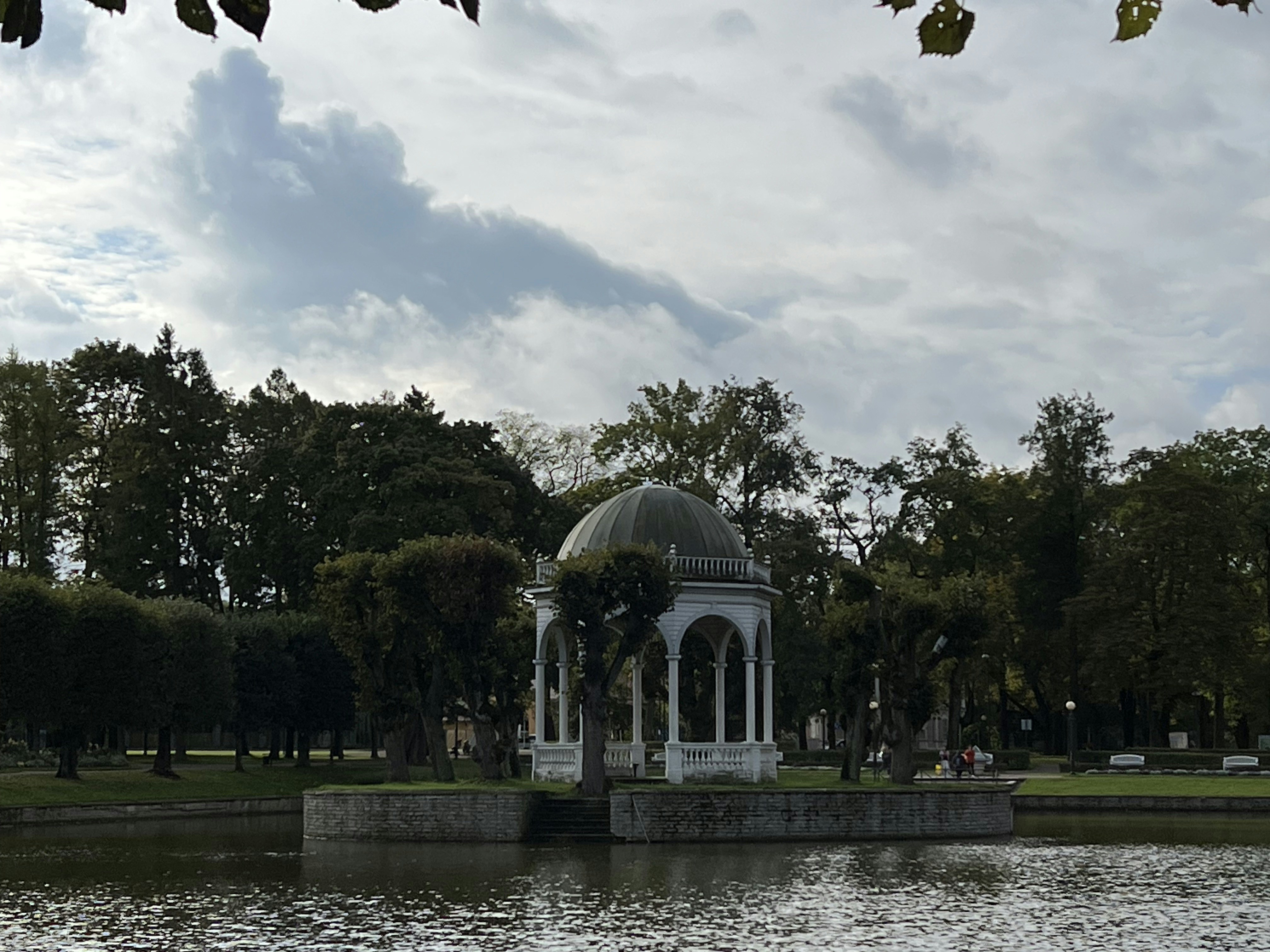 A gazebo in the middle of a lake surrounded by trees
