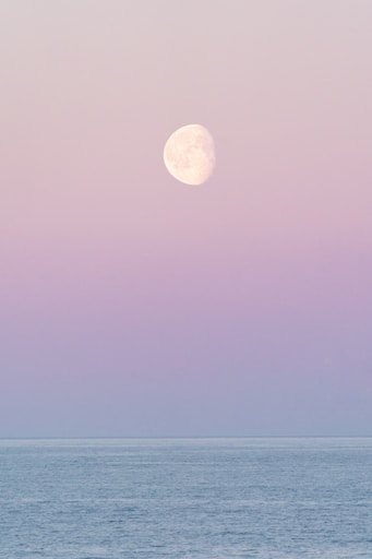 A full moon is seen over the ocean