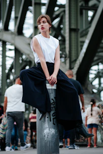 A woman is sitting on top of a pole