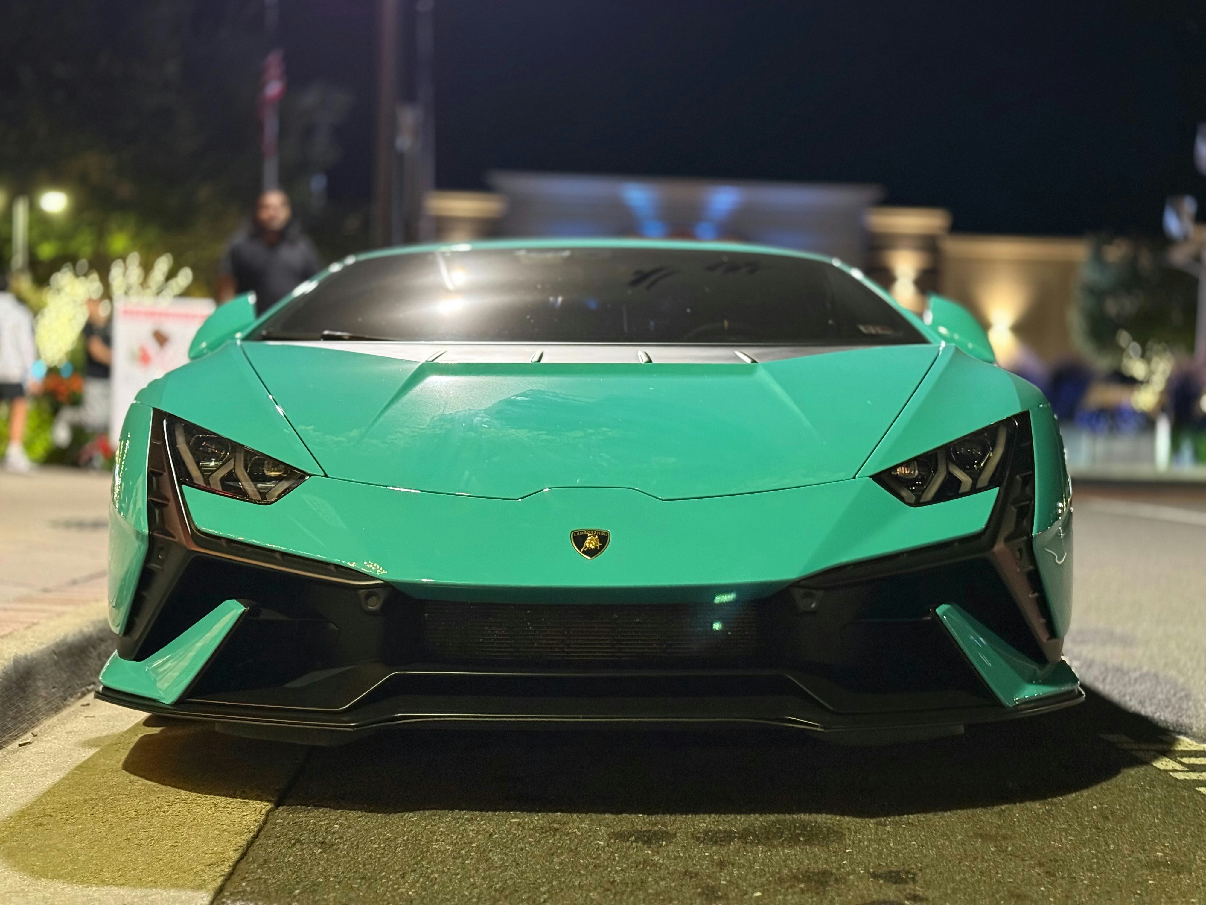 A green sports car parked on the side of the road