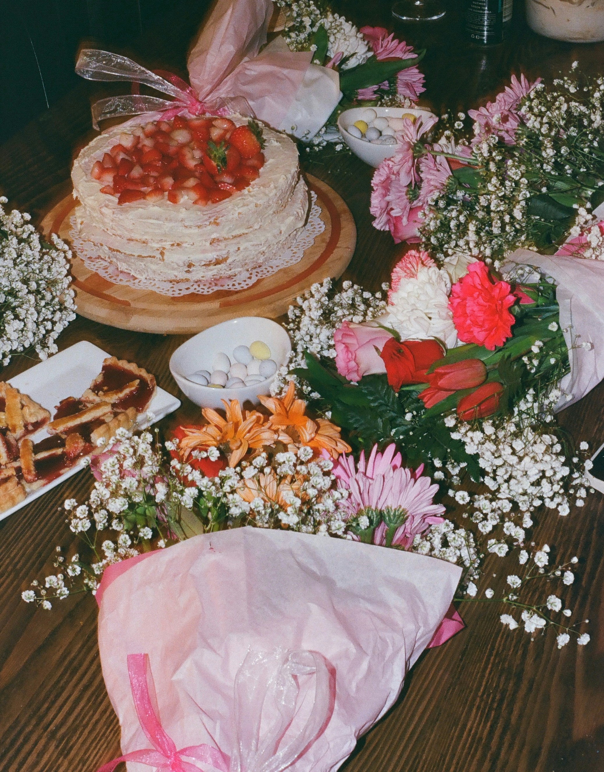A table topped with a cake covered in flowers