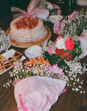 A table topped with a cake covered in flowers