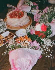 A table topped with a cake covered in flowers
