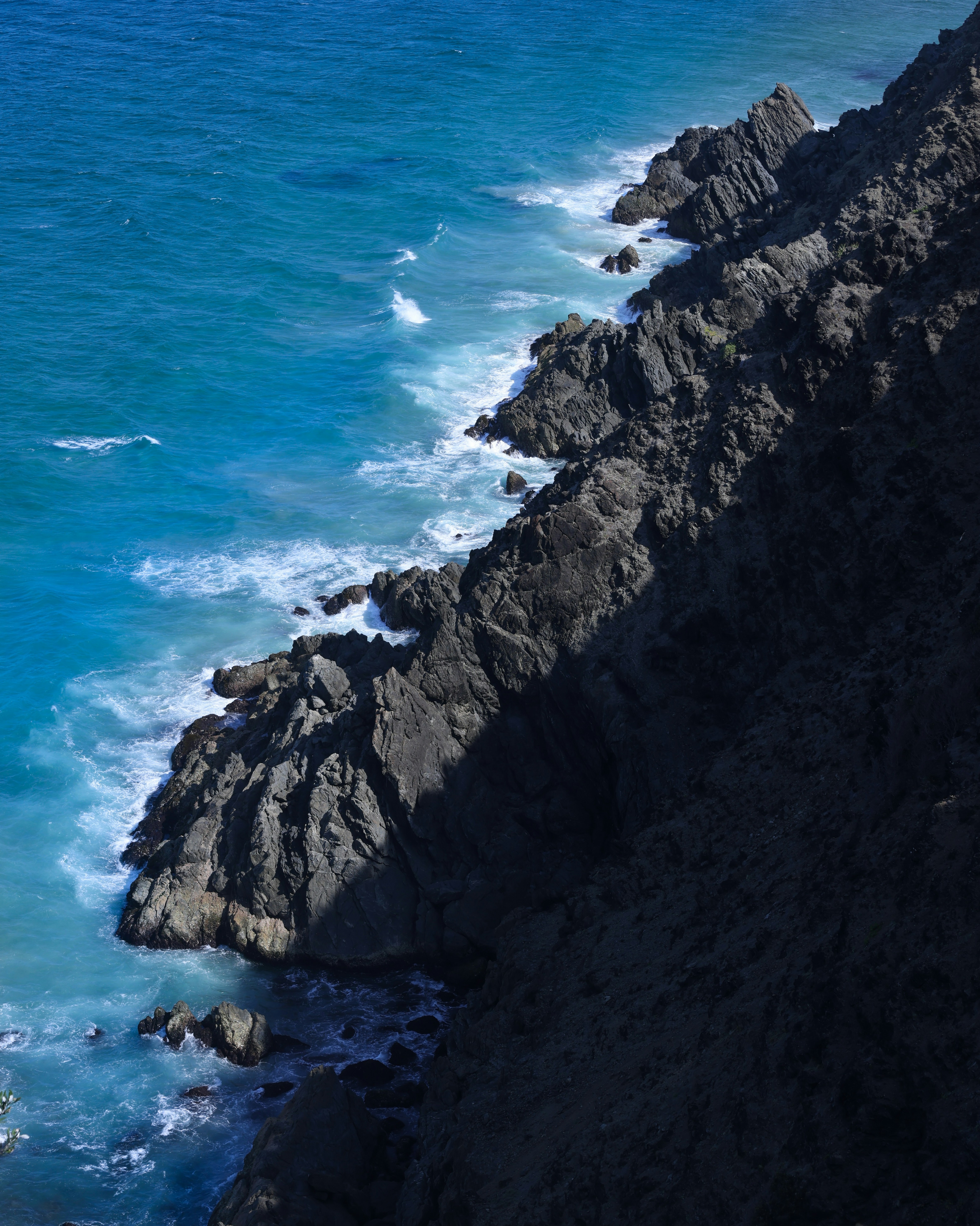 A man riding a surfboard on top of a cliff near the ocean