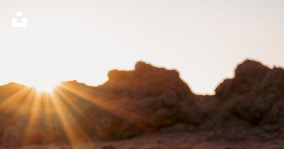 The sun shines brightly through the rocks in the desert photo – Free ...