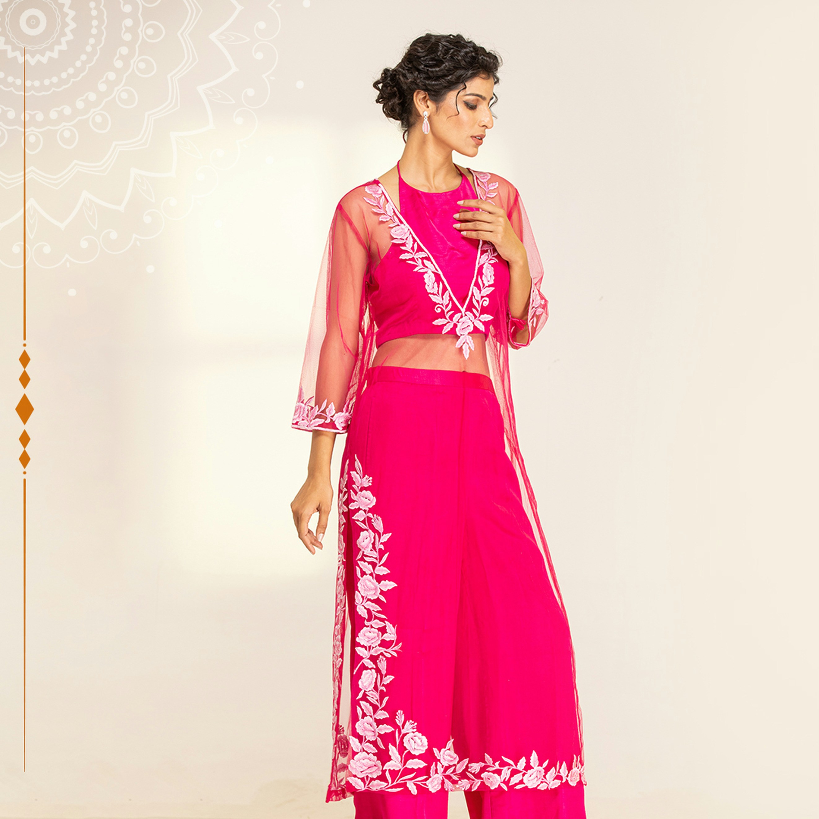 A woman in a pink outfit standing in front of a wall