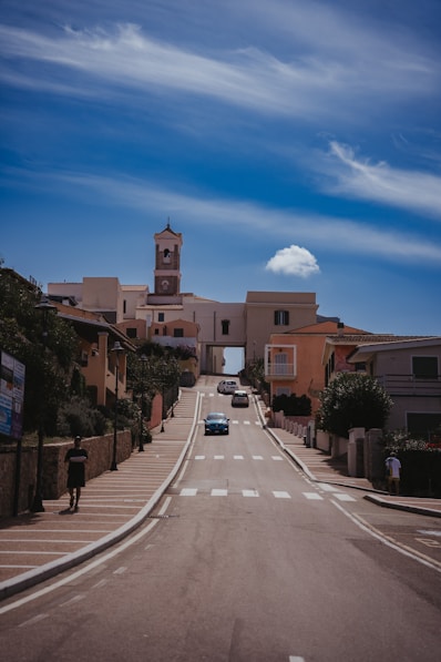 A car driving down a street next to tall buildings