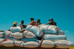 A group of people sitting on top of a large pile of sandbags