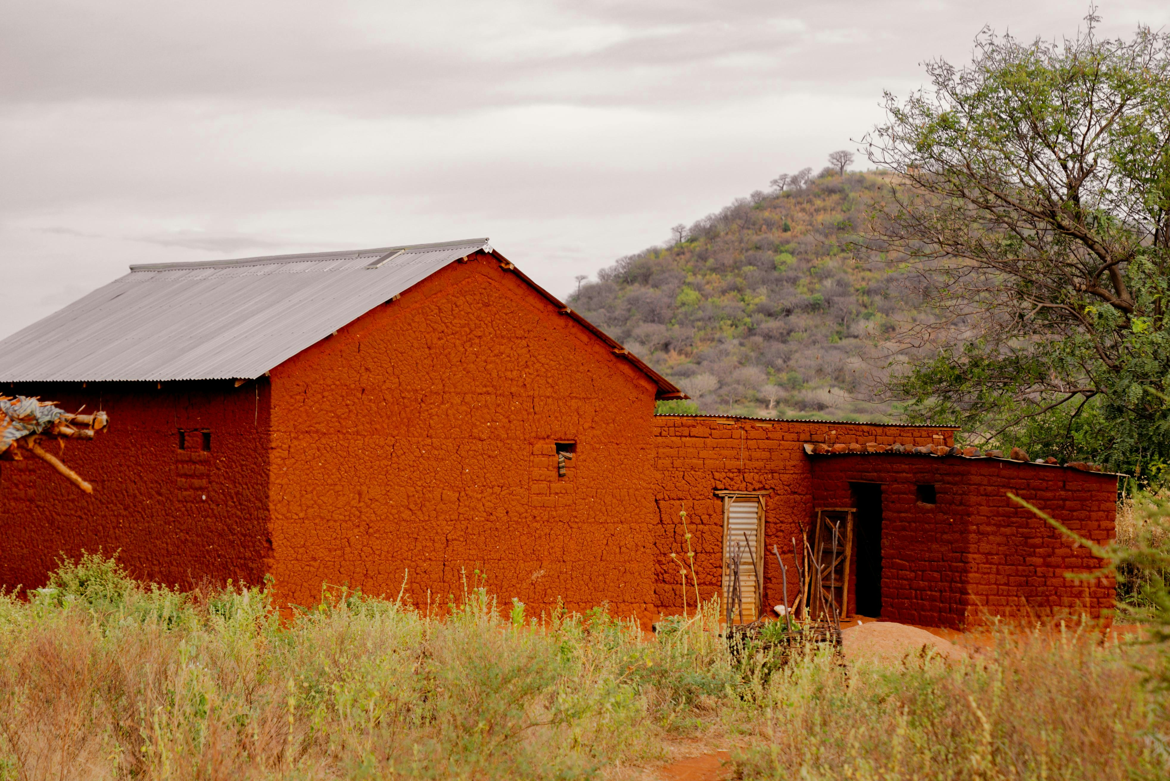 A red building in the middle of a field