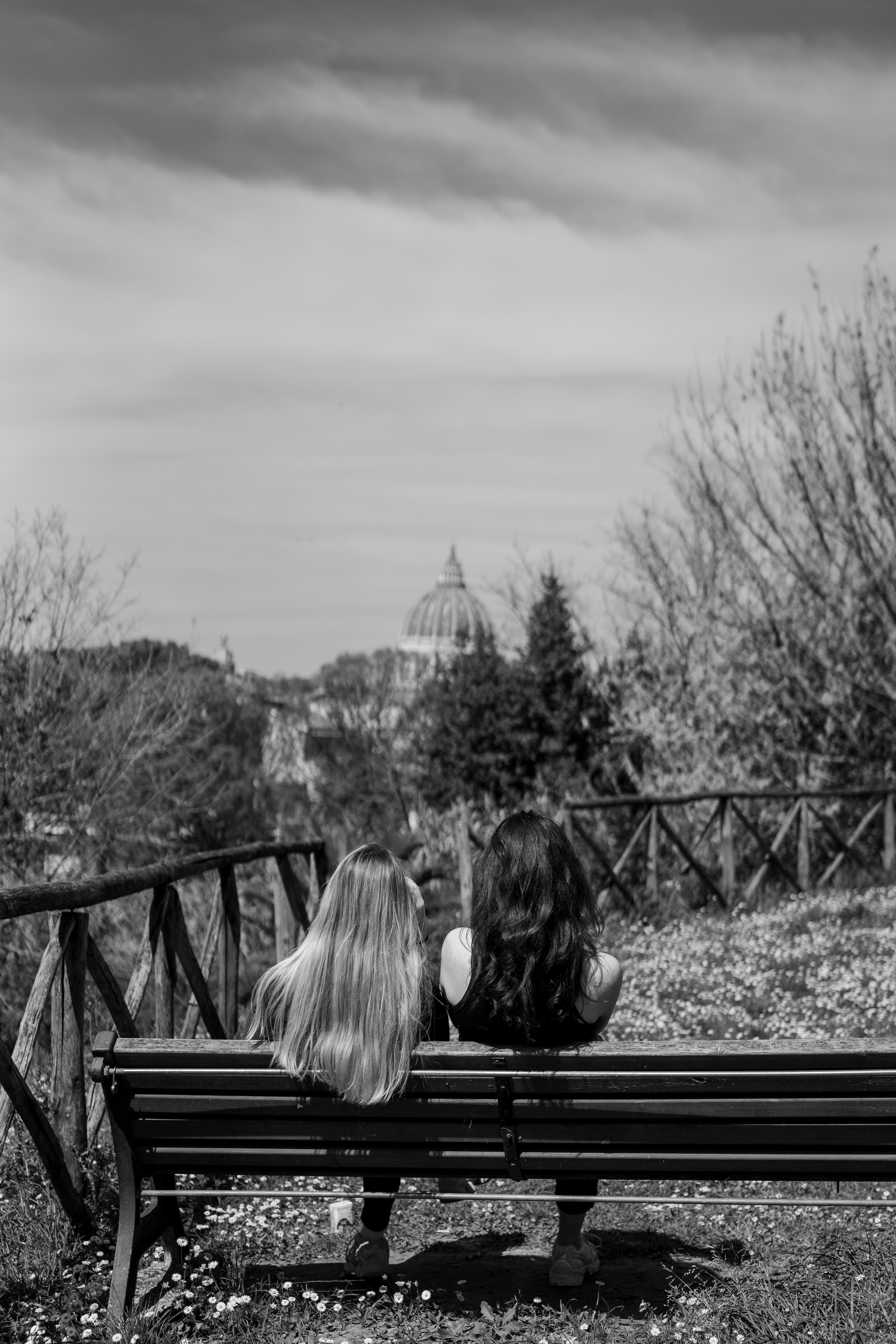 Ein paar Frauen sitzen auf einer Holzbank