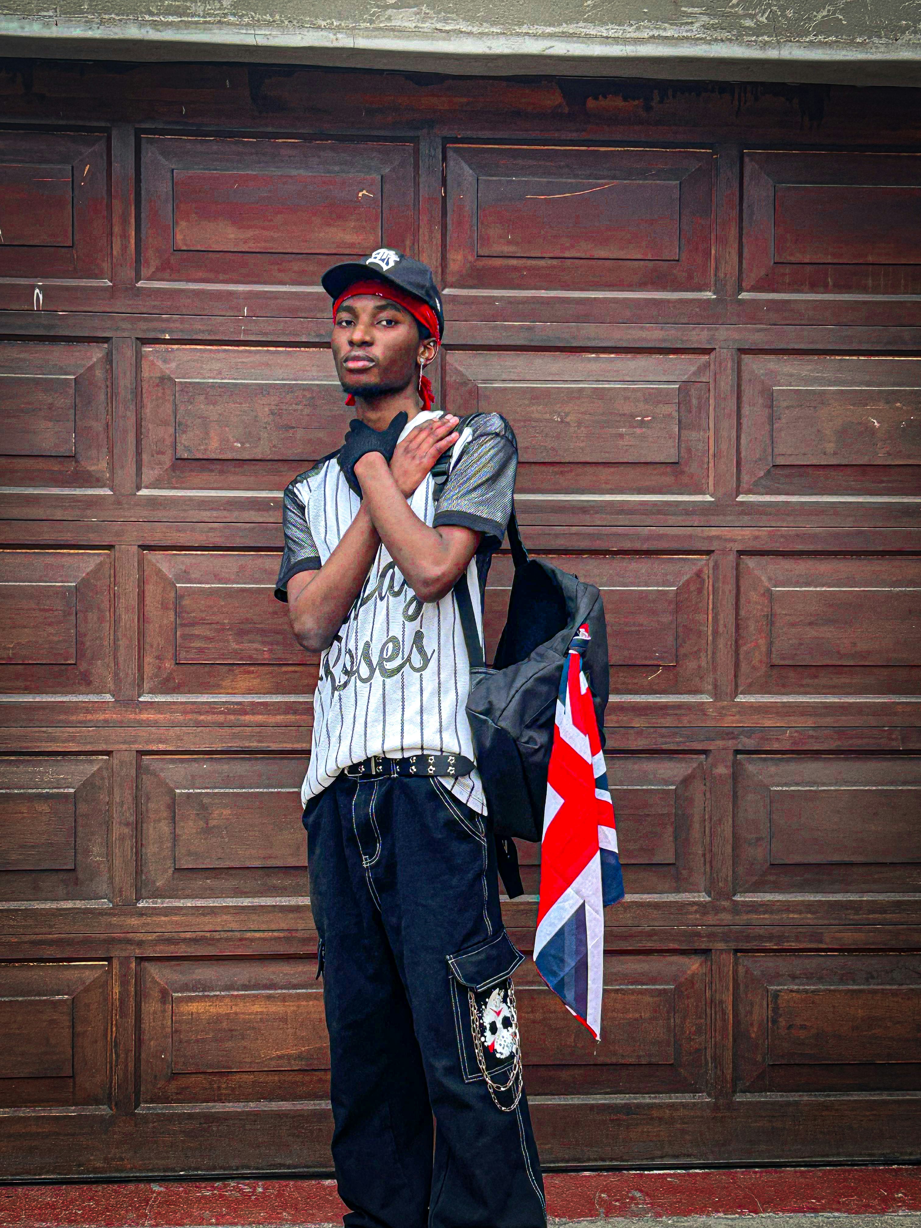 A young man standing in front of a garage door