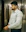 A man in a white shirt leaning against a wall