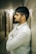 A man leaning against a wall with his arms crossed