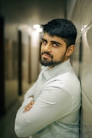 A man leaning against a wall with his arms crossed
