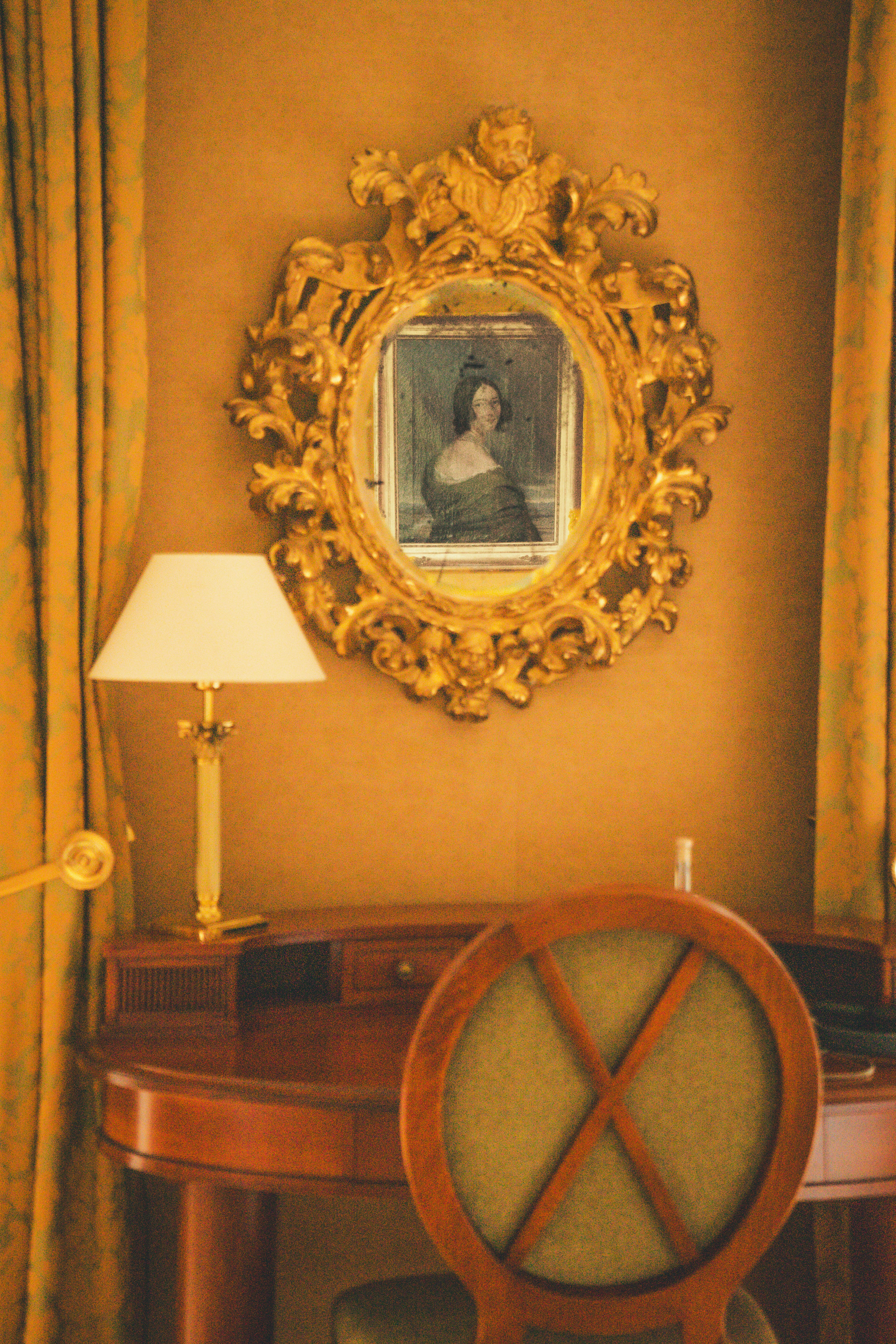 A desk with a chair and a mirror on the wall