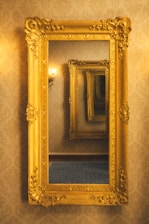 A gold framed mirror hanging on a wall