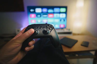 A person holding a video game controller in front of a computer