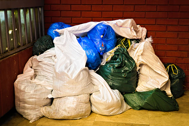A pile of garbage sitting next to a brick wall