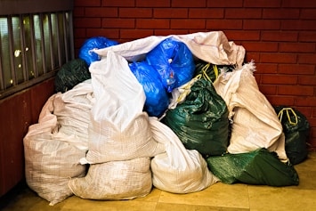 A pile of garbage sitting next to a brick wall