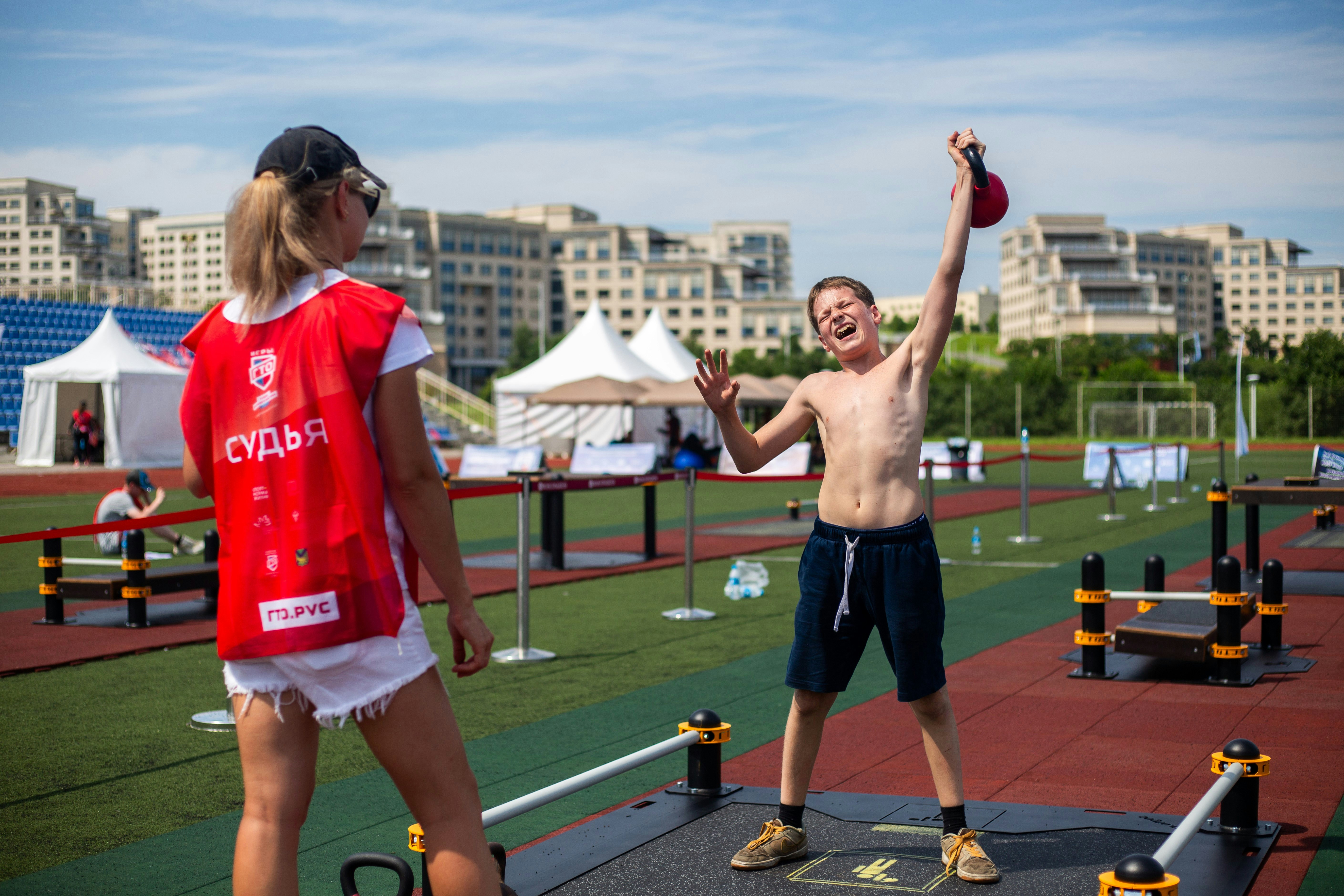 A man holding a red frisbee standing next to a woman