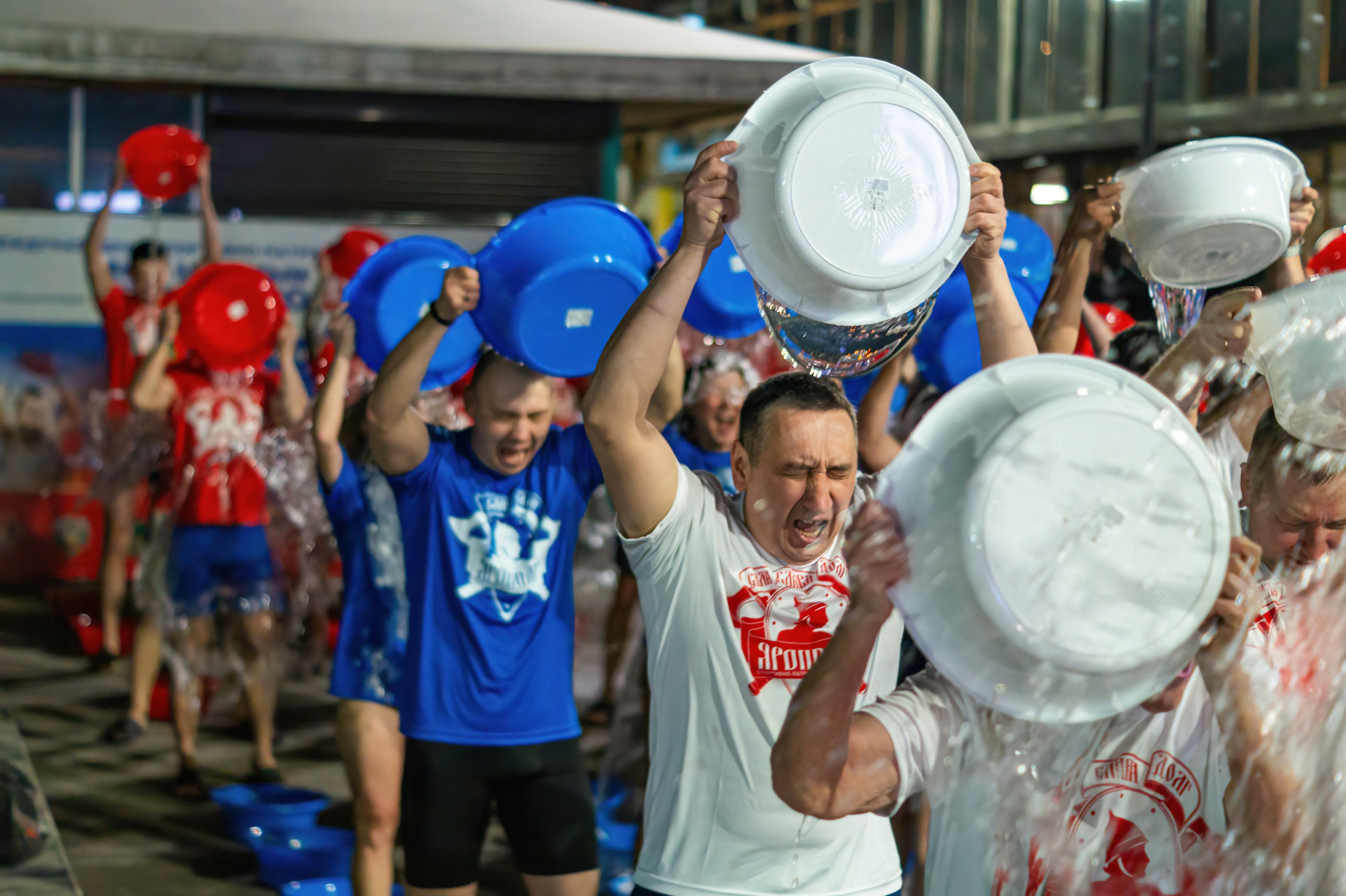 A group of people holding up white frisbees