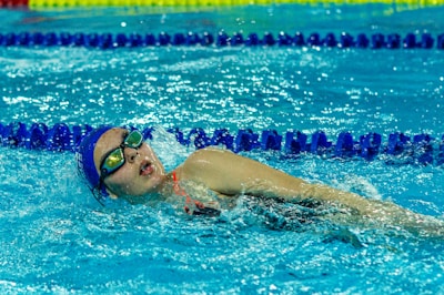 A woman swimming in a pool with goggles on