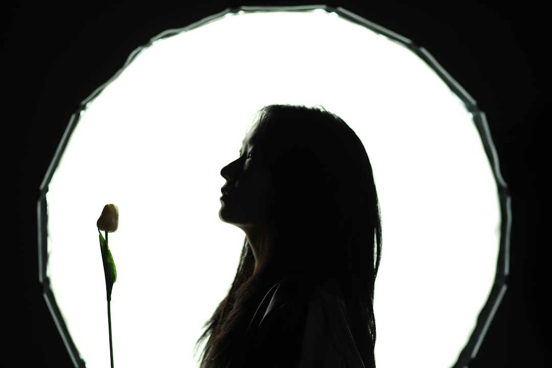 A woman standing in front of a circular light,