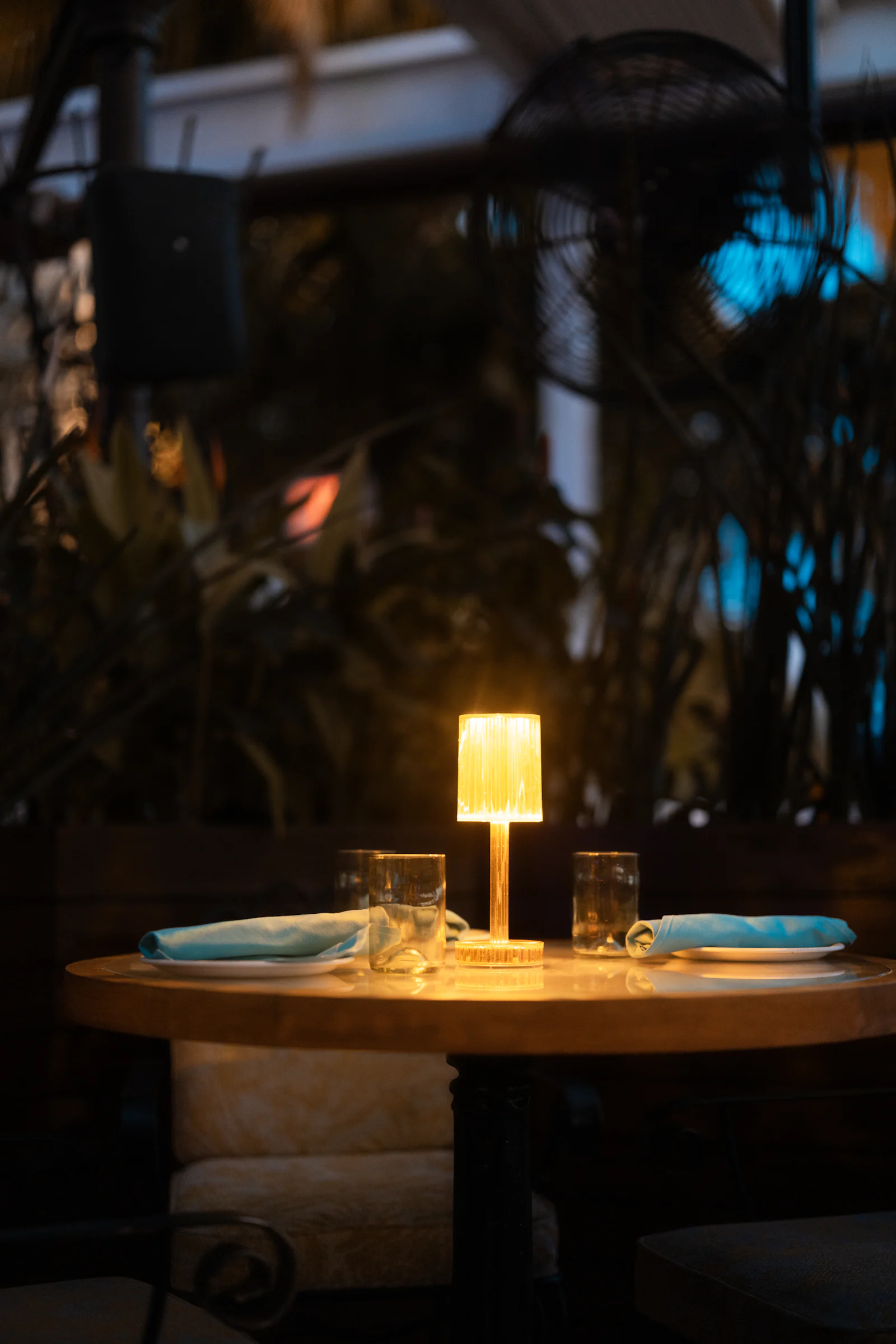 Mesa servida a la luz de las velas en un entorno tropical al anochecer