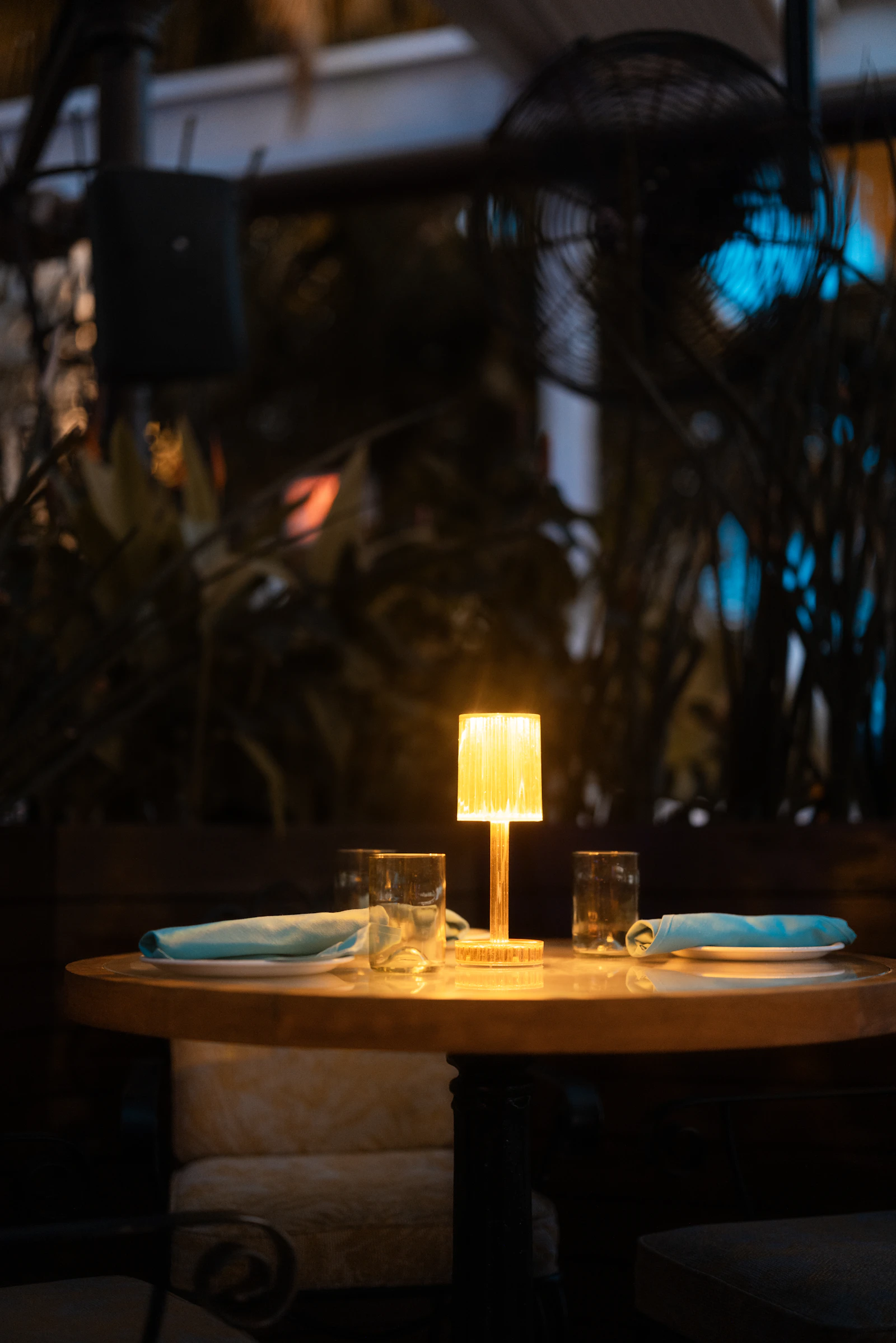 Mesa servida a la luz de las velas en un entorno tropical al anochecer