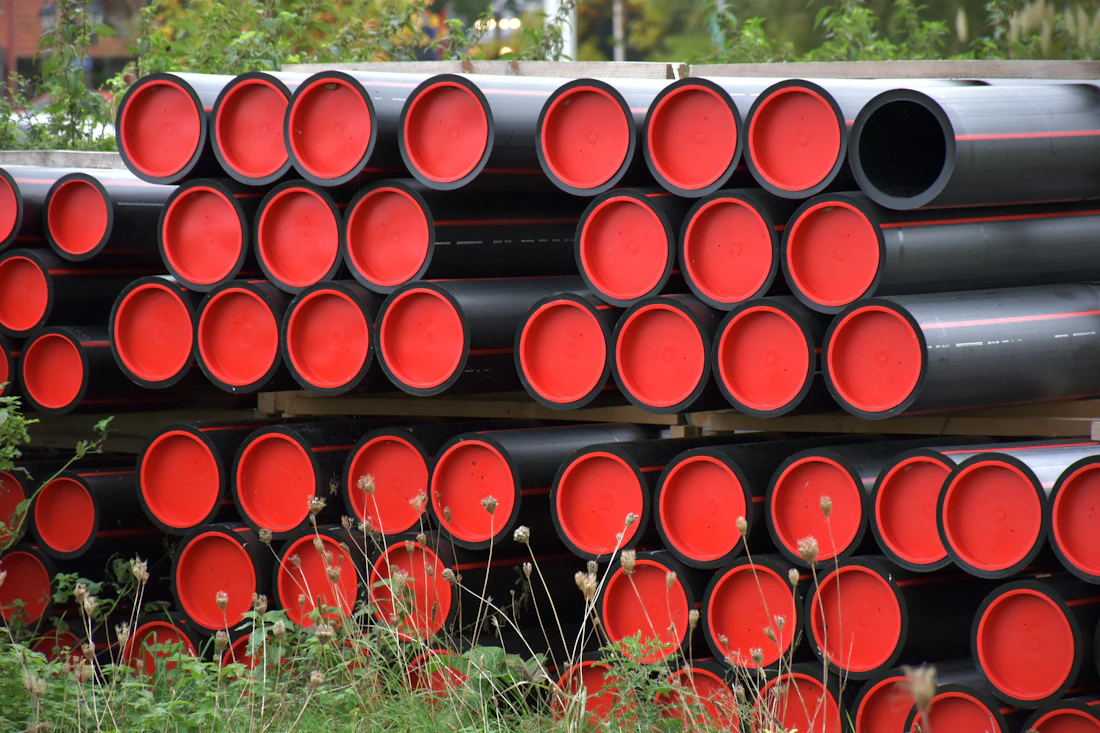 Stacks of large-diameter HDPE pipe staged in a supply yard