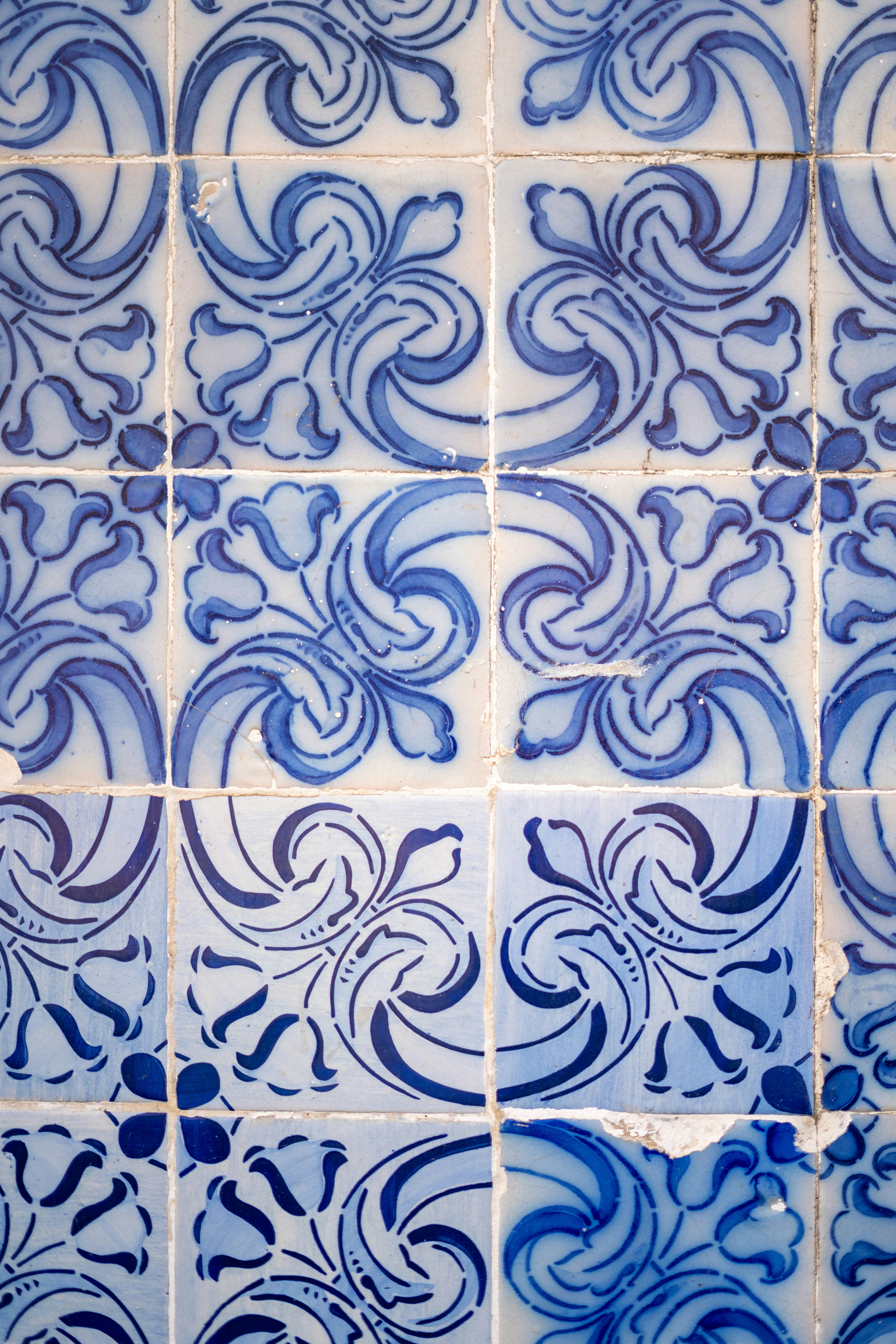A blue and white tiled wall with blue swirls