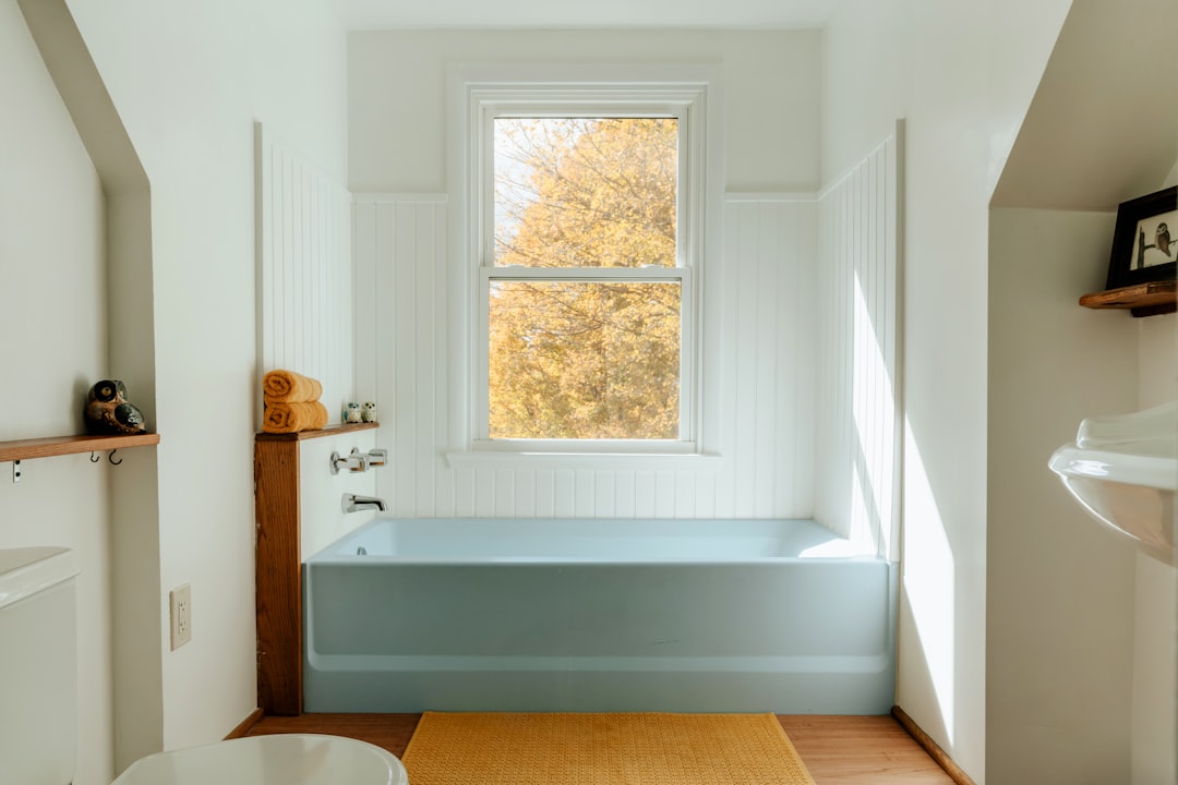 A bathroom with a tub, sink, and window, Blue tub (IG: @clay.banks)