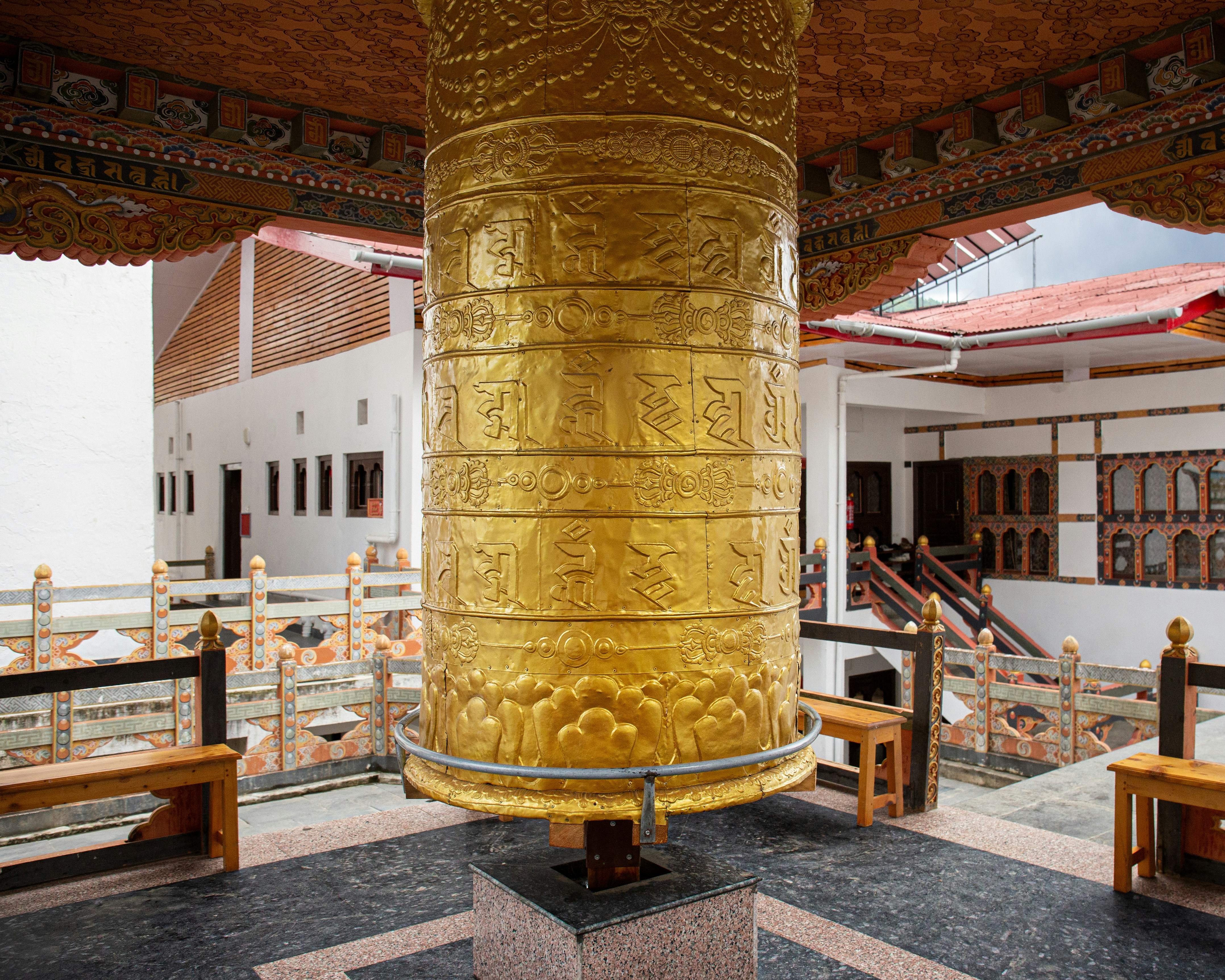 A large golden pillar sitting in the middle of a building, 