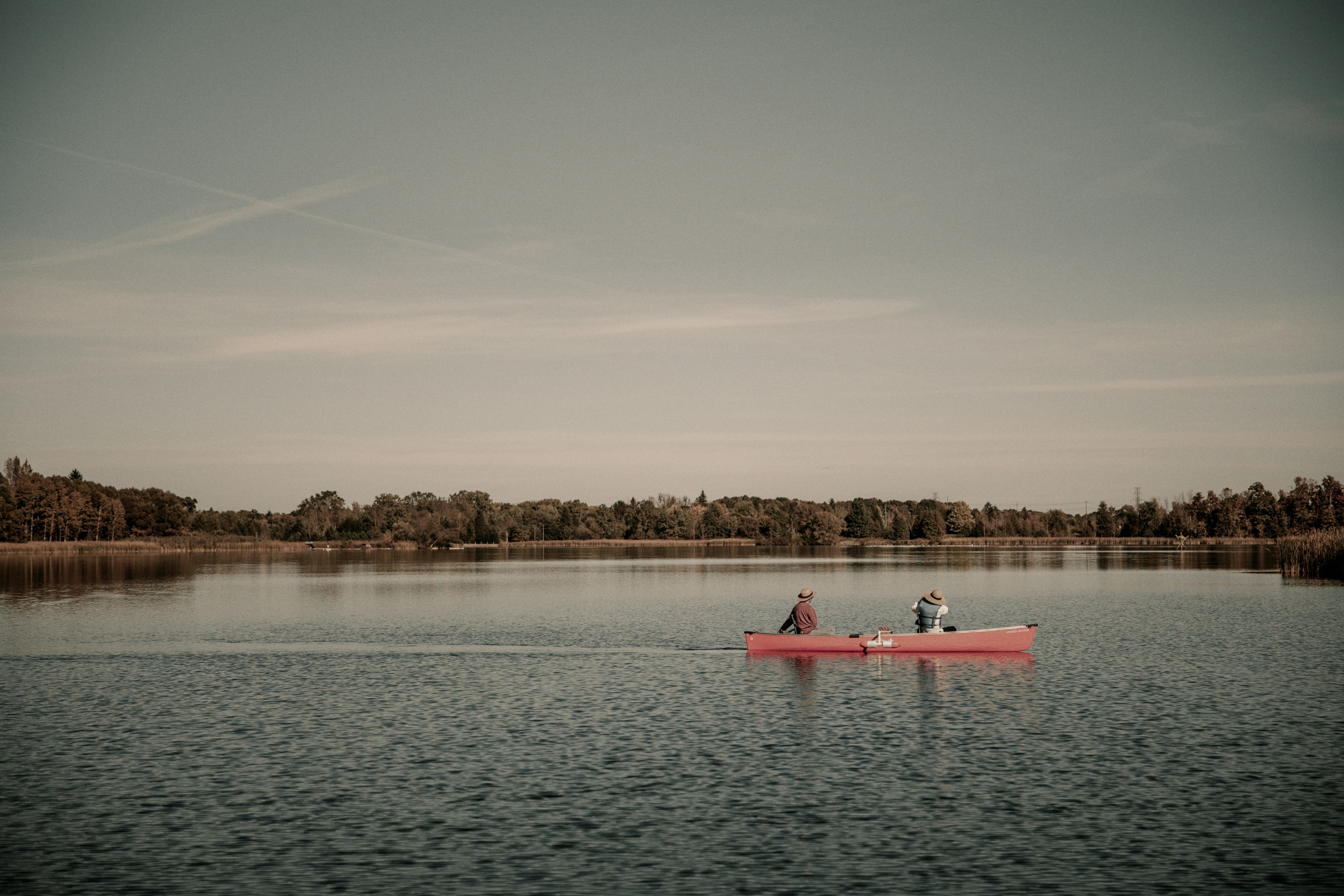 Two people in a red boat on a lake