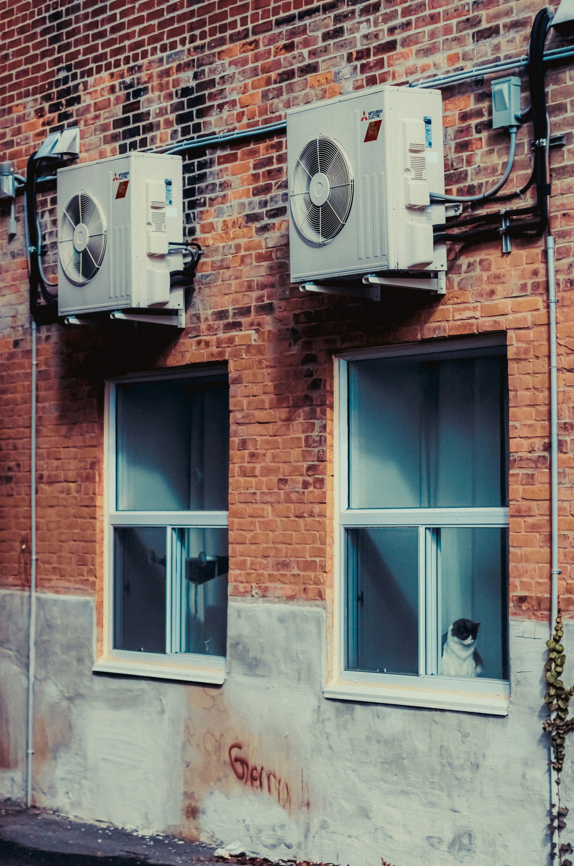 A brick building with two air conditioners on the side of it