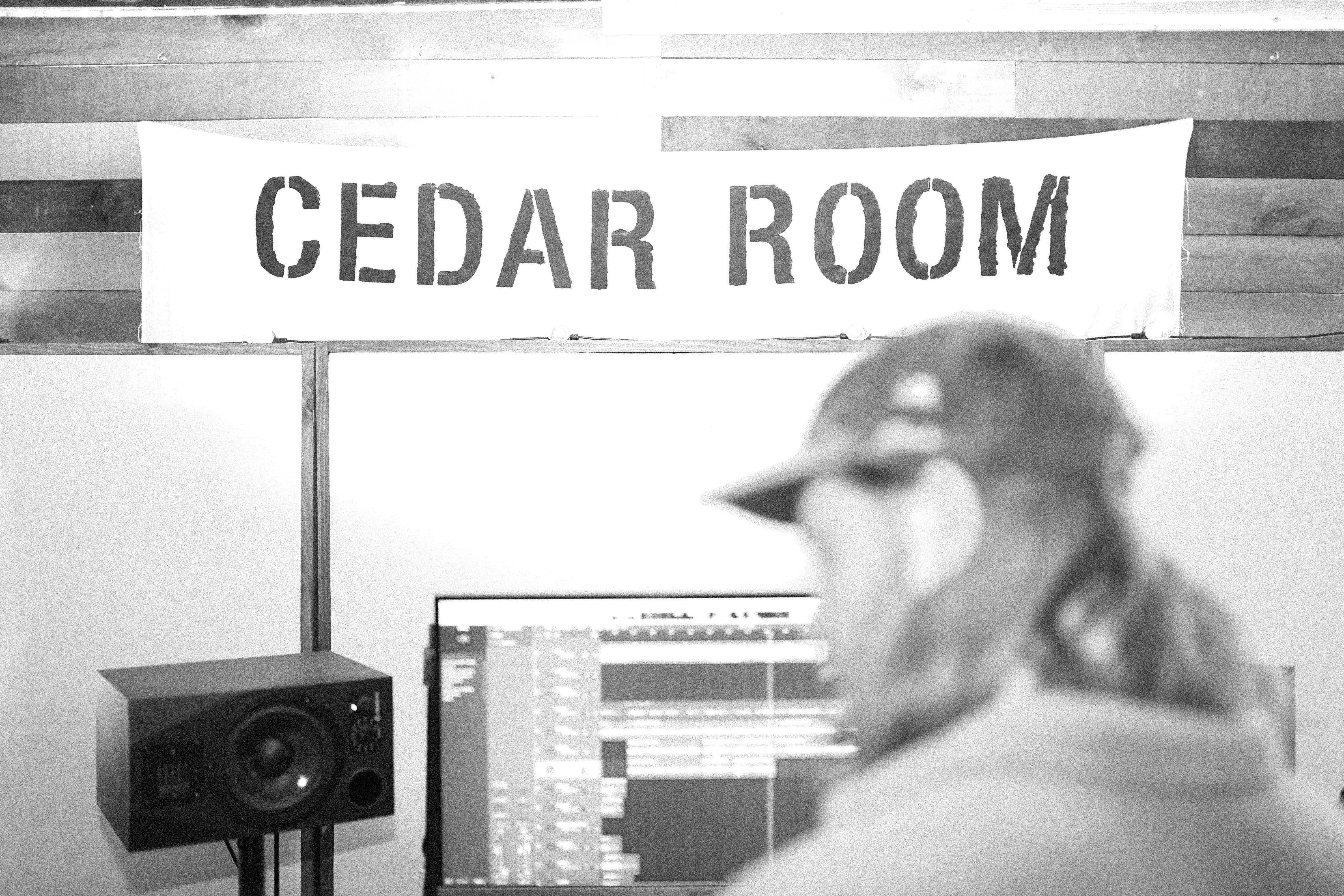 A man in a baseball cap standing in front of a recording studio
