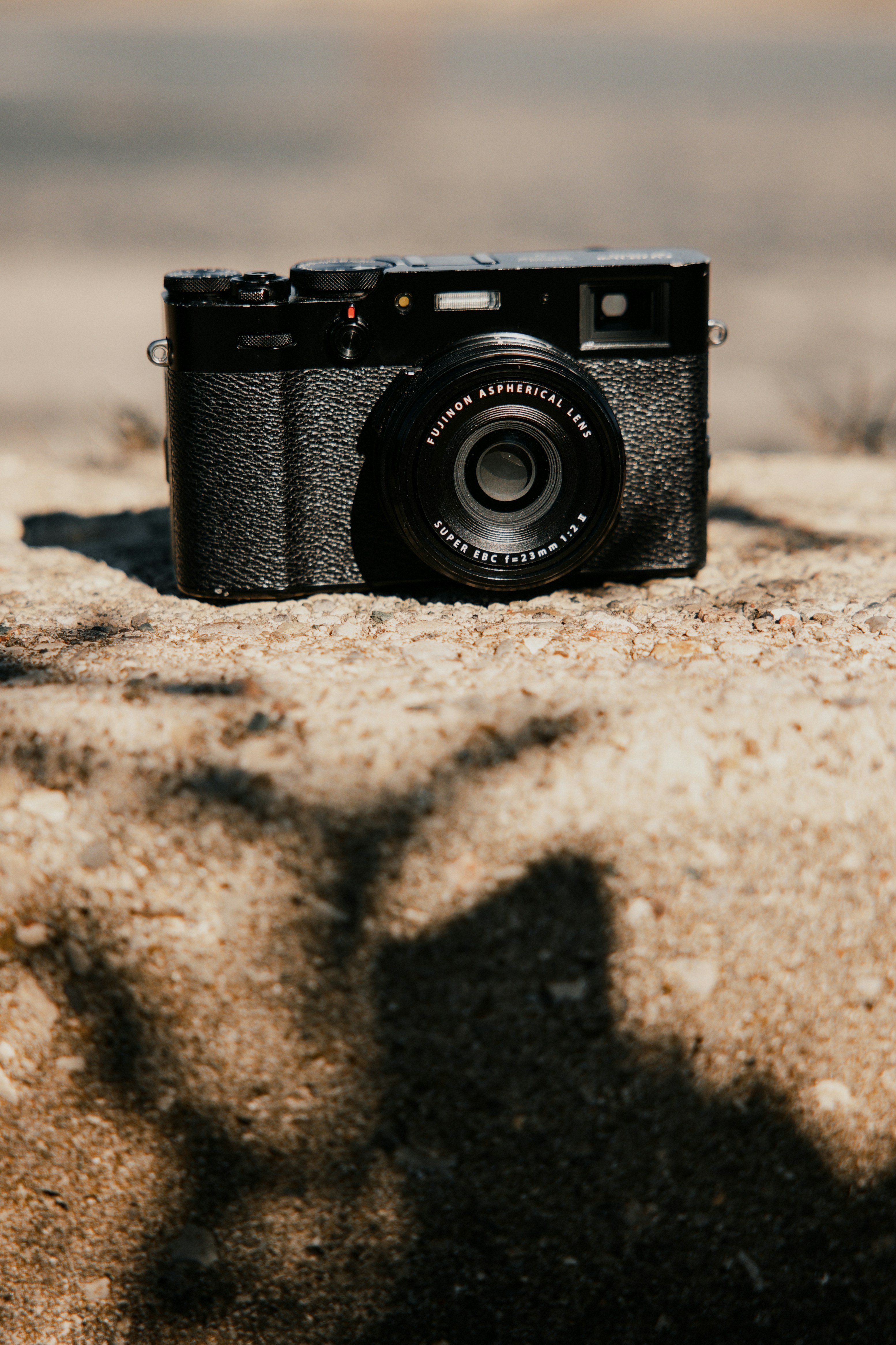 A black camera sitting on top of a rock