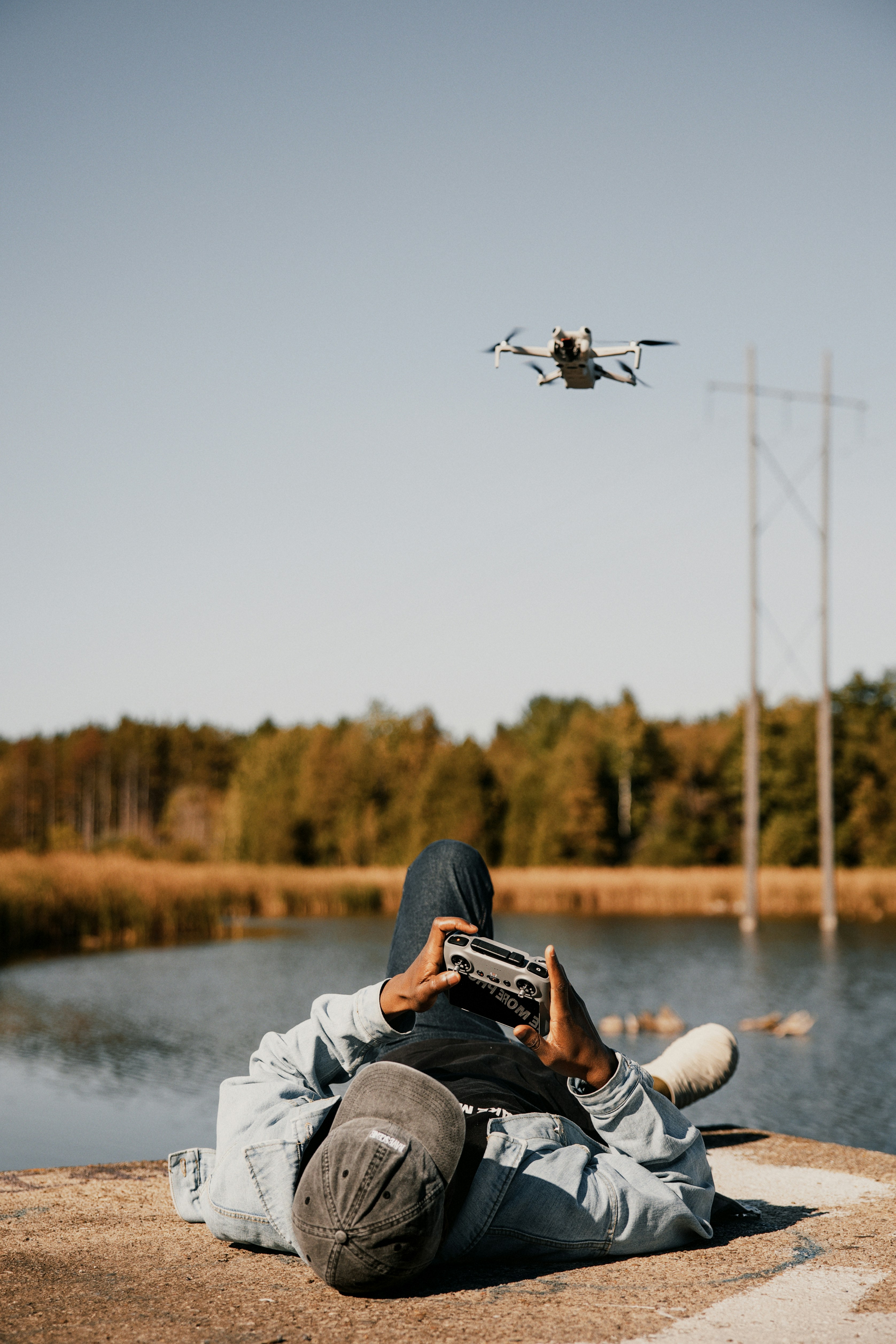 A person sitting on a rock looking at a remote control plane
