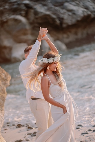 A bride and groom dancing on the beach