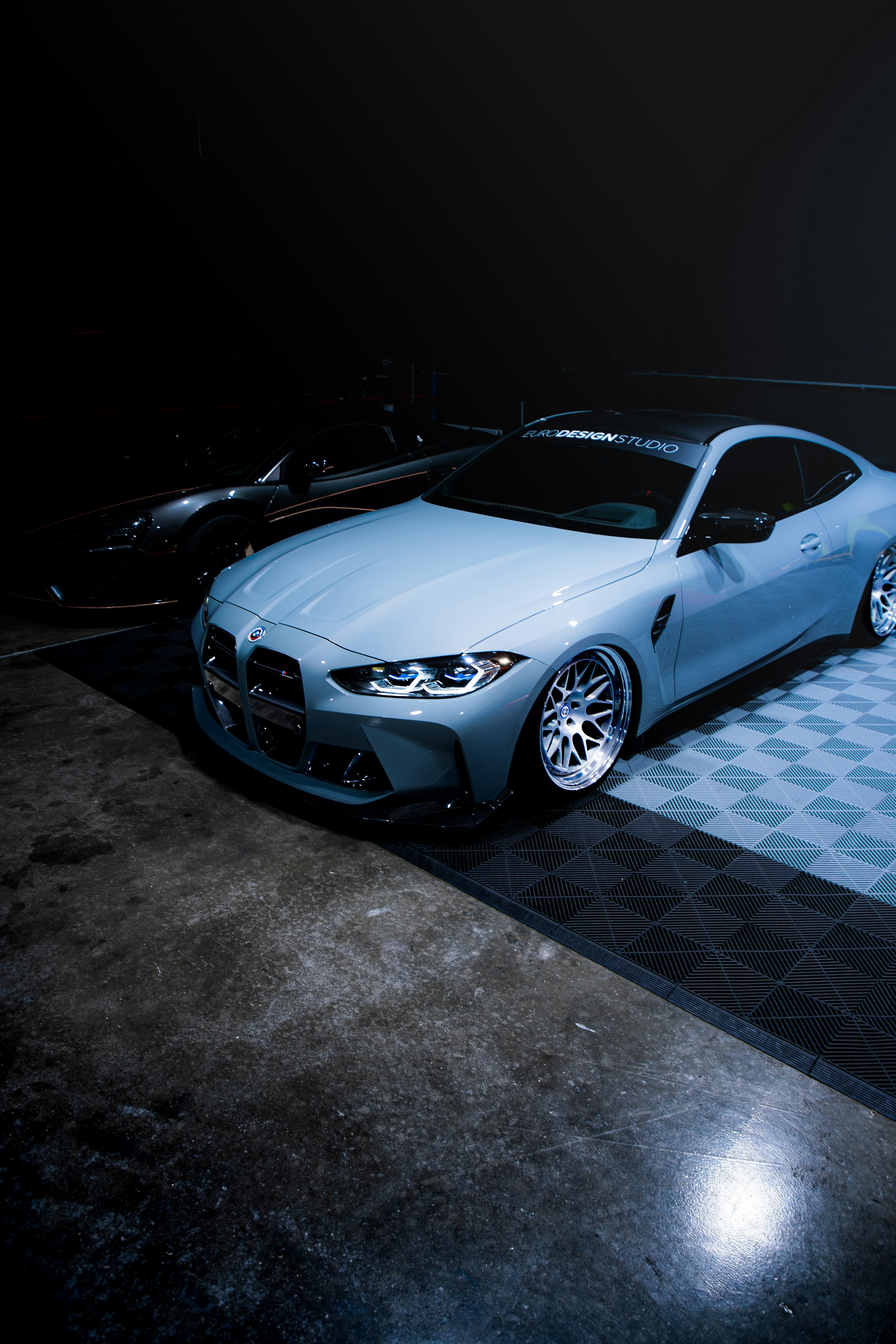 Ein blaues Auto parkt auf einem karierten Boden