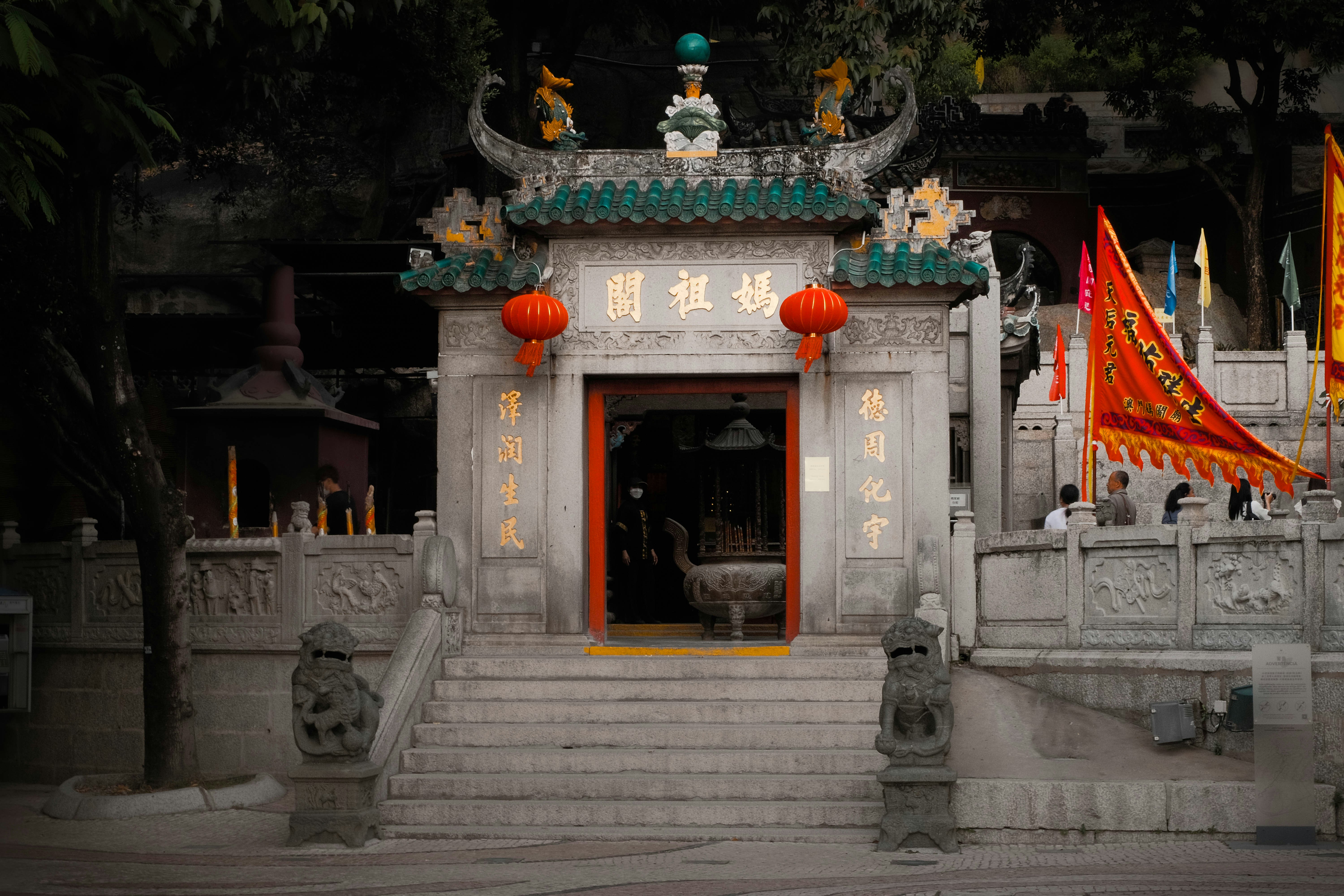 A white building with a red door and red lanterns