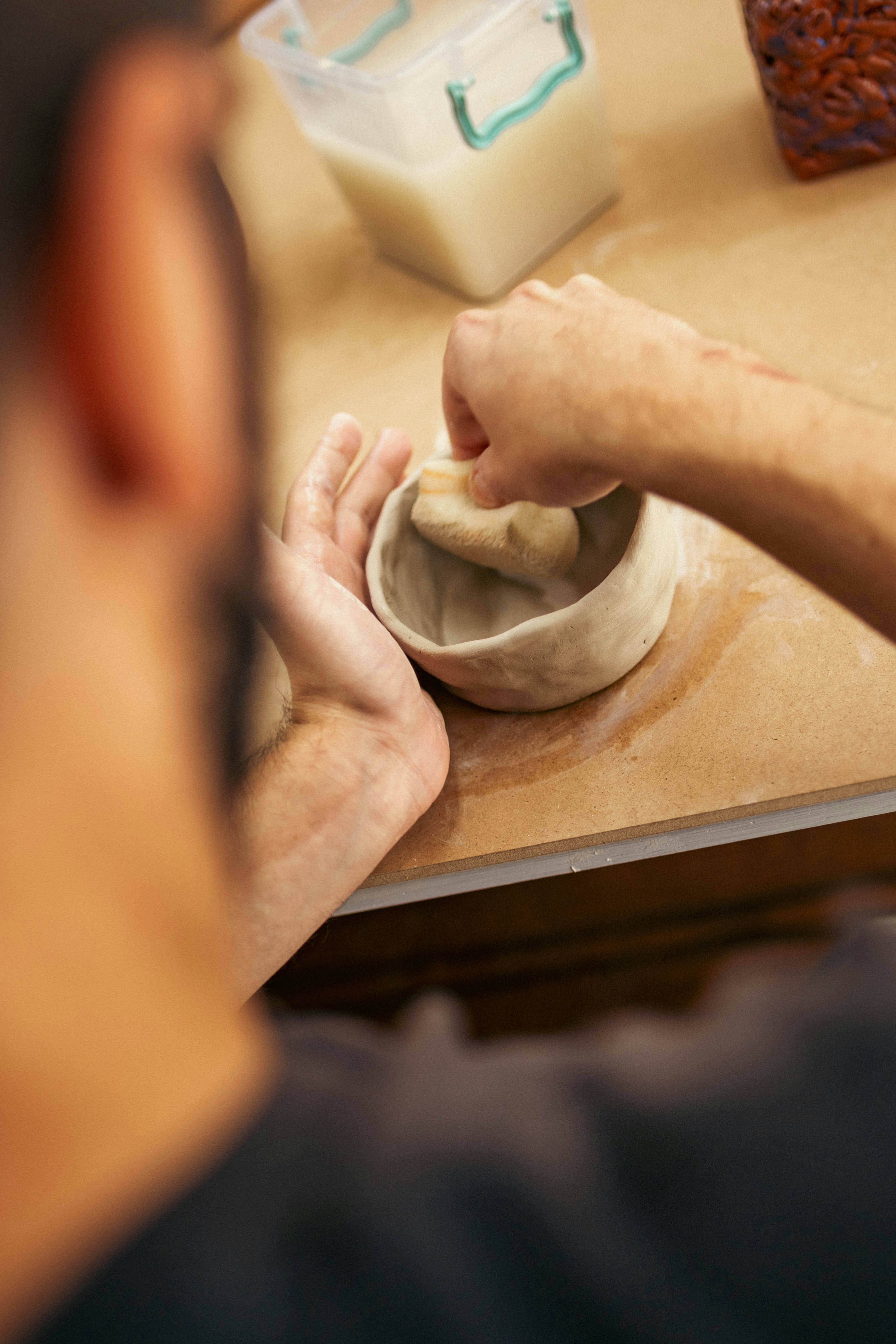 A man is kneading dough into a bowl
