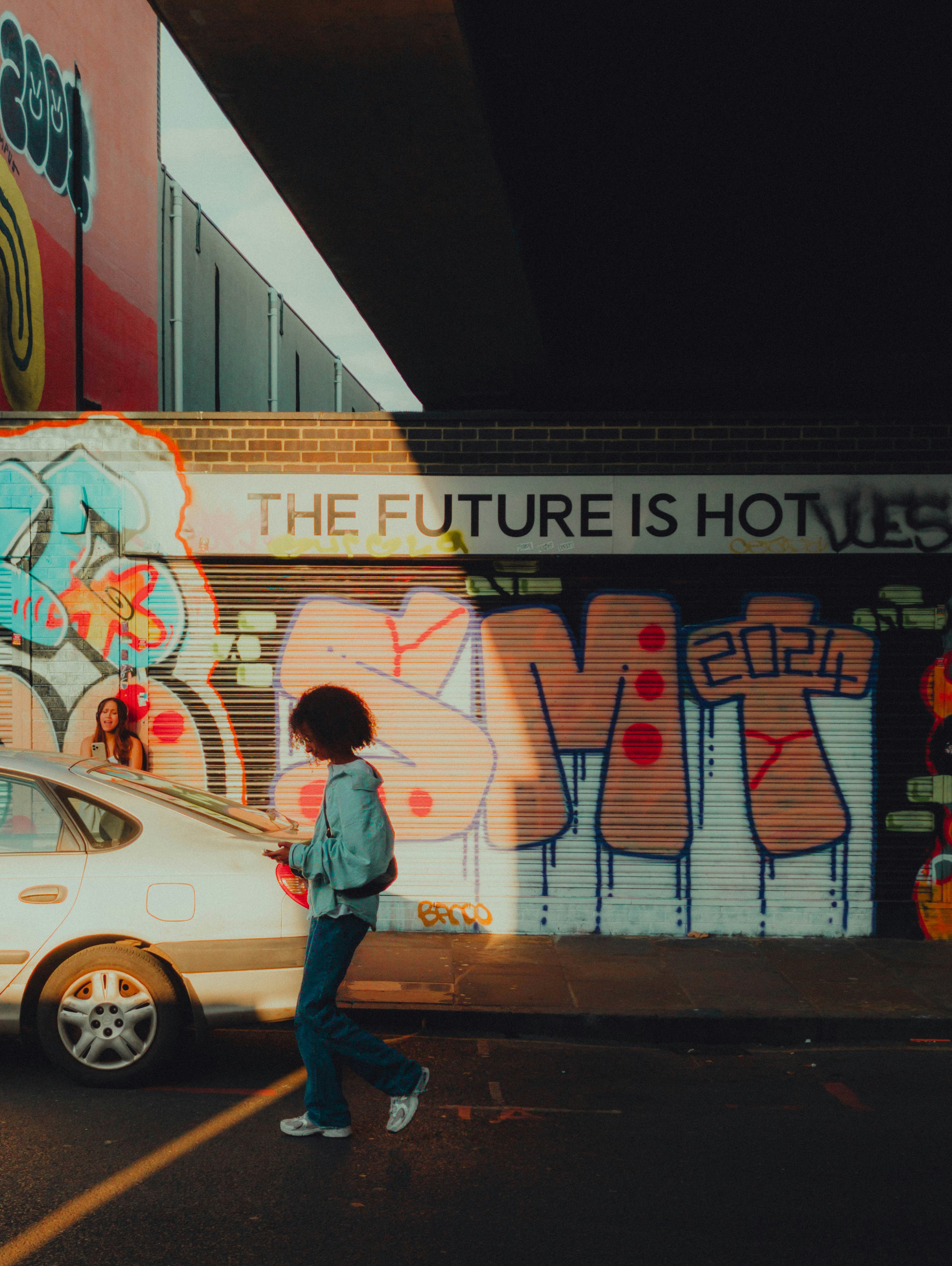 A person standing in front of a building with graffiti on it