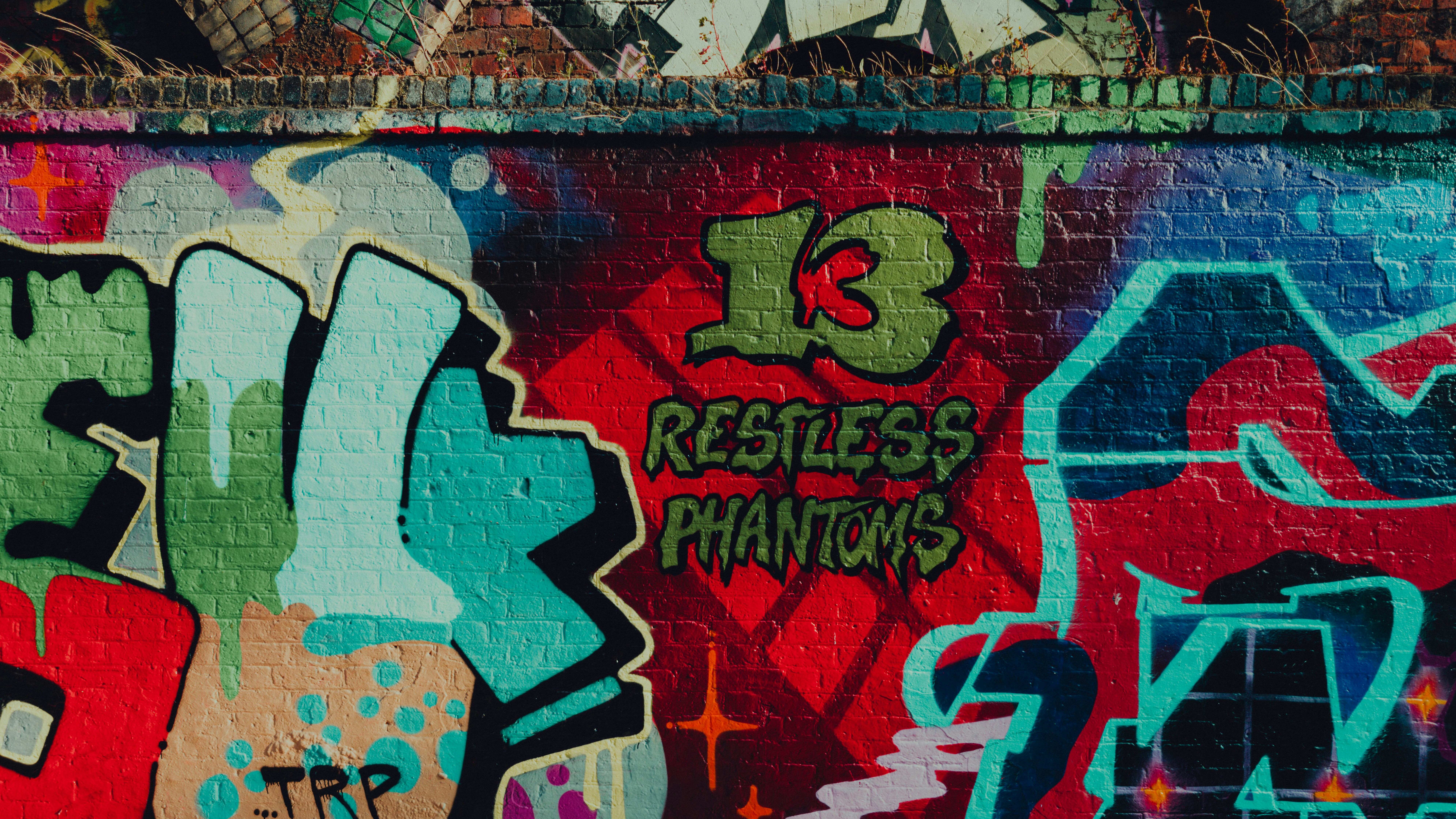 A wall covered in lots of colorful graffiti