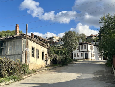 An old run down street with a house in the background