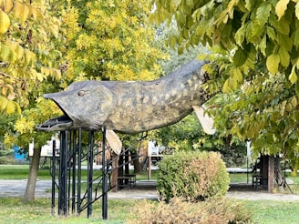 A sculpture of a fish in a park