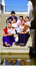 A group of people sitting on steps next to a body of water