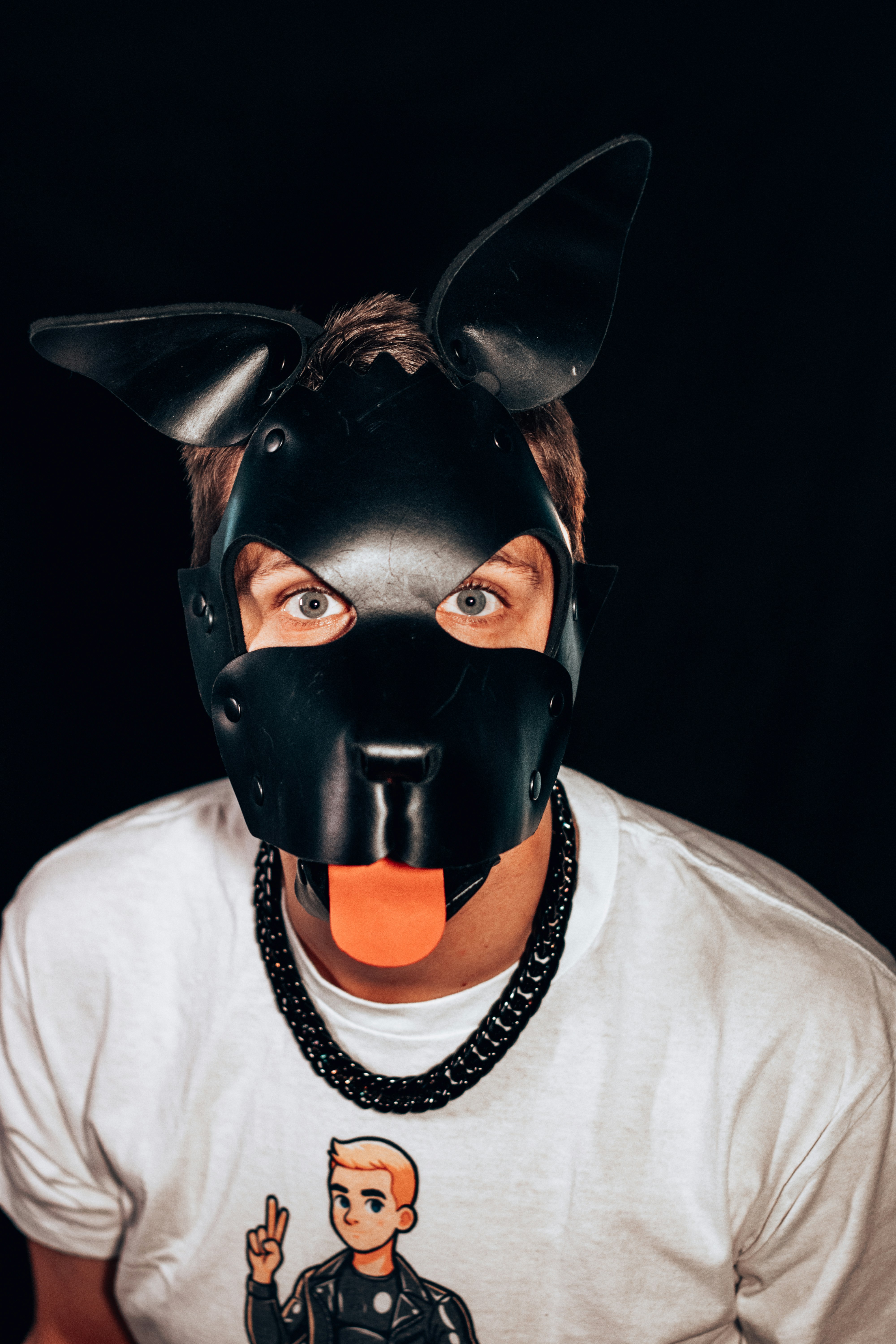 A man wearing a black mask with an orange tongue